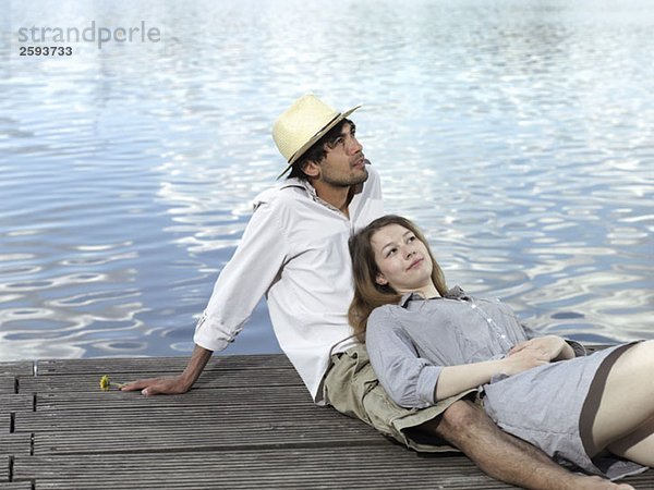 Ein junges Paar auf einem Steg sitzend