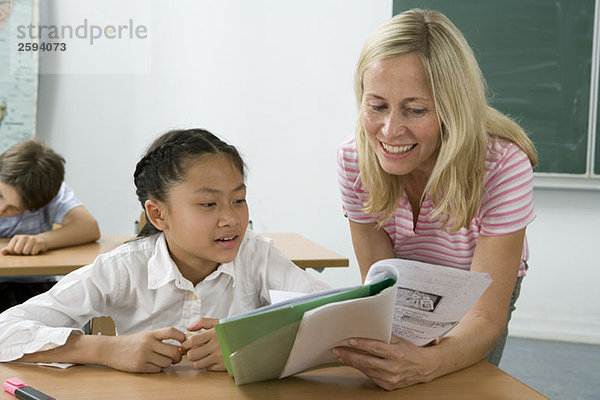 Ein Lehrer hilft einem Schüler im Klassenzimmer.