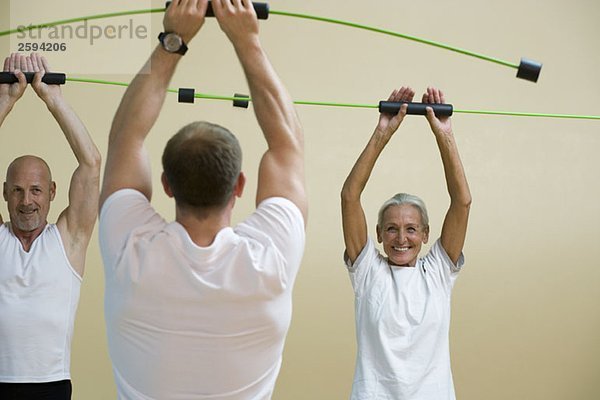 Ein Fitnesstrainer  der eine aerobe Flex-Bar-Klasse unterrichtet.