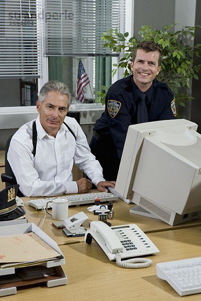 Zwei Polizisten  die in einem Büro arbeiten.