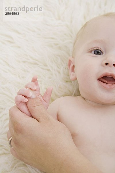 Eine menschliche Hand  die die Hand eines Babys hält.