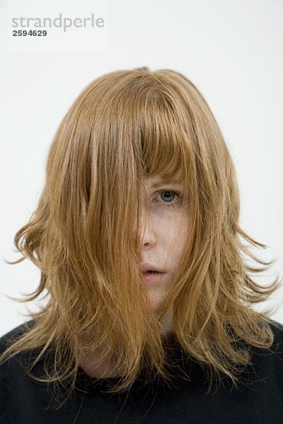 Eine Frau mit strubbeligen Haaren im Gesicht.