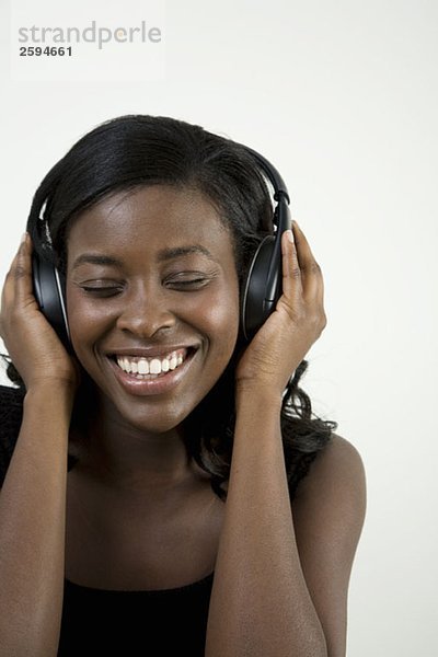 Eine Afroamerikanerin  die Kopfhörer hört.