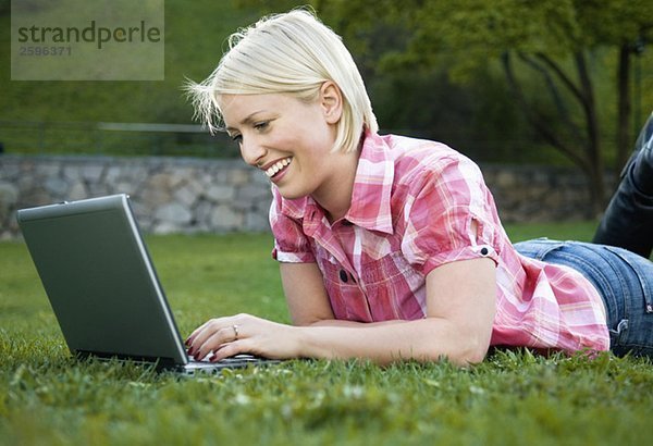 Mädchen im Park mit ihrem Computer