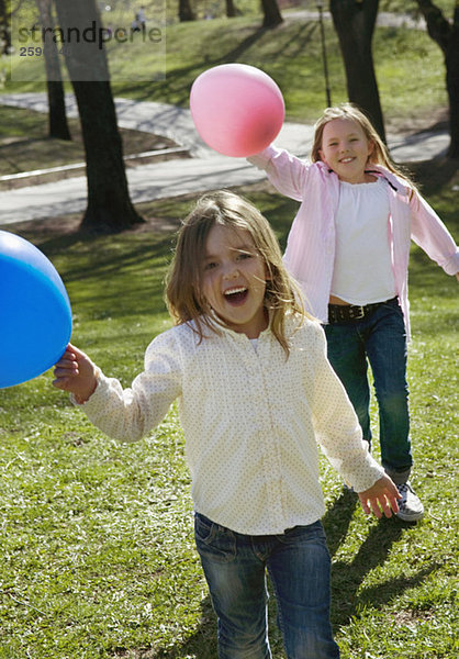 Schwestern spielen mit Luftballons