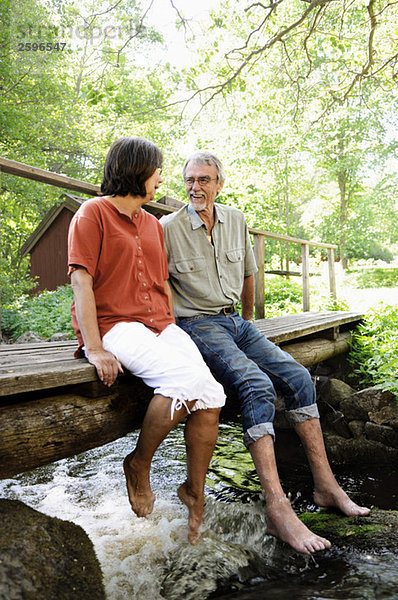 Mann und Frau sitzen auf der Brücke