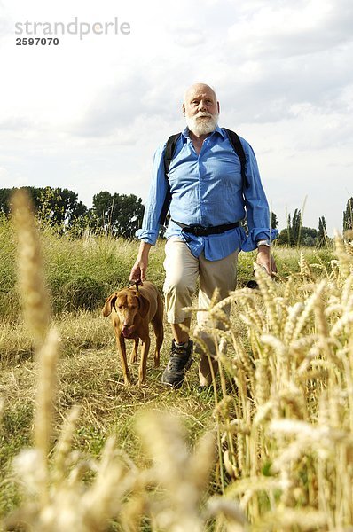 Mann gehen Hund reifer Erwachsene reife Erwachsene Feld
