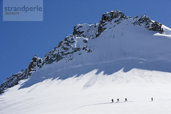 Silhouettierte Skitourenfahrer am Berg