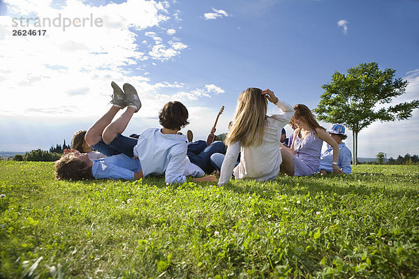 Teenagergruppe auf Gras im Park liegend