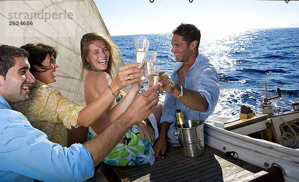 Zwei Paare machen einen Toast auf dem Segelboot