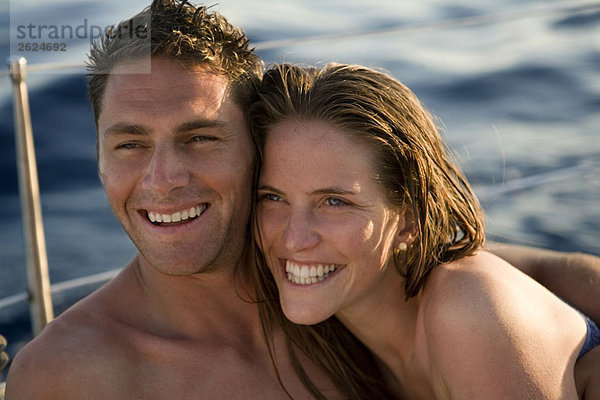 Paar lächelt auf dem Boot auf See