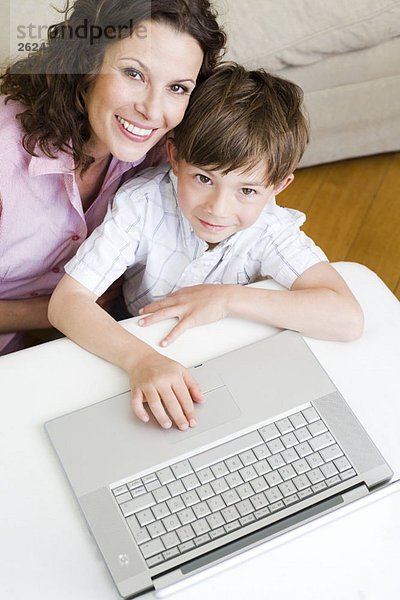 Frau und Sohn schauen mit Laptop nach oben