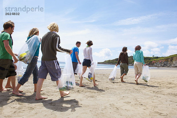 Junge Leute sammeln Müll am Strand