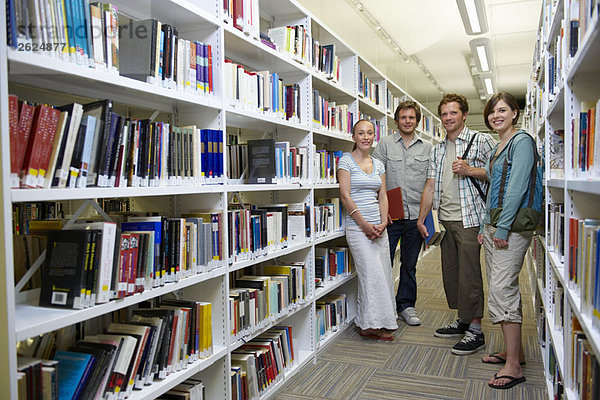 Vier junge Studenten in einer Bibliothek
