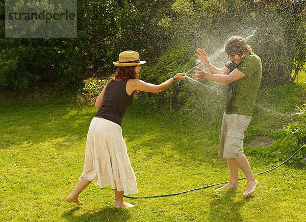 Frau Spritzmann mit Gartenschlauch