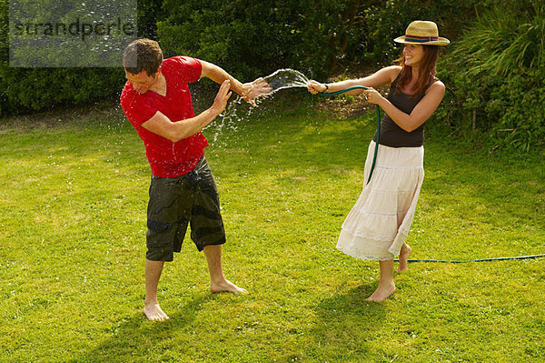 Frau Spritzmann mit Gartenschlauch