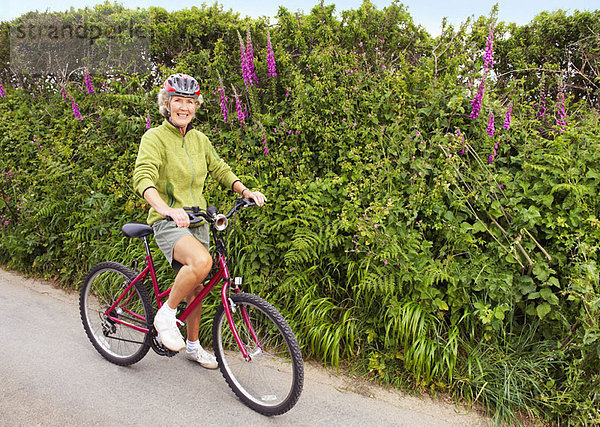 Seniorin posiert mit Fahrrad