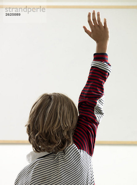 Junge erhebt Hand im Klassenzimmer