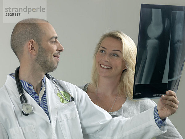 Arzt und Frau mit Röntgenbild