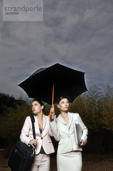 2 Frauen unter einem Schirm
