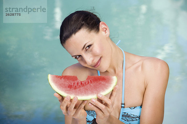 Junge Frau im Bikini mit Melone  Portrait