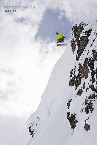 Austria  Tyrol  Zillertal  Gerlos  Freeride skiing  Man doing jump across rock