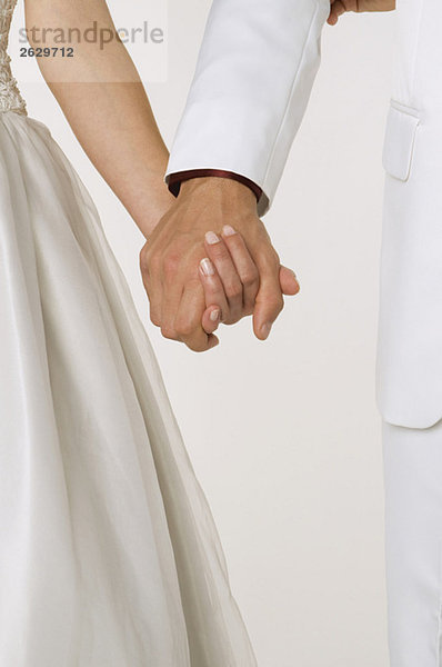 Braut und Bräutigam beim Händchenhalten  Mittelteil  Nahaufnahme