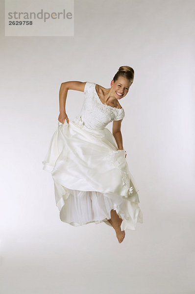 Junge Braut springend in der Luft  lachend