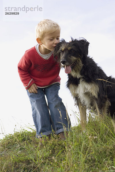 Kleiner Junge (3-4) spielt mit Hund