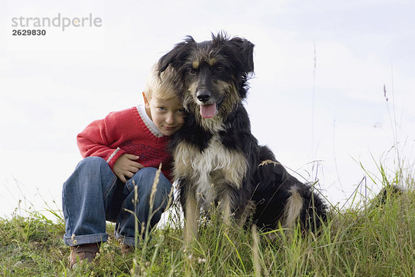 Kleiner Junge (3-4) spielt mit Hund