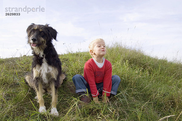 Kleiner Junge (3-4) spielt mit Hund