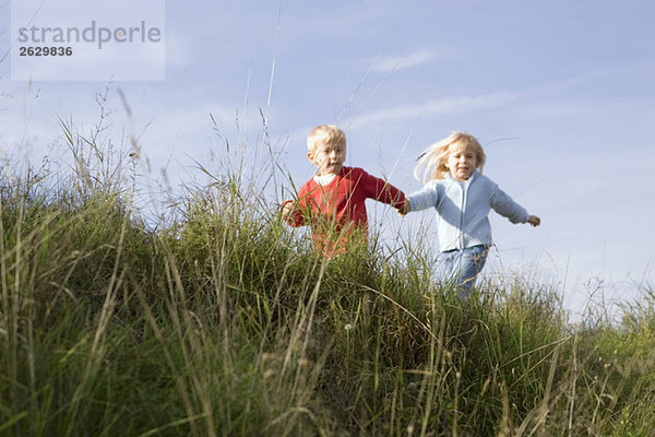 Kleiner Junge und Mädchen (3-4) beim Spielen im Freien