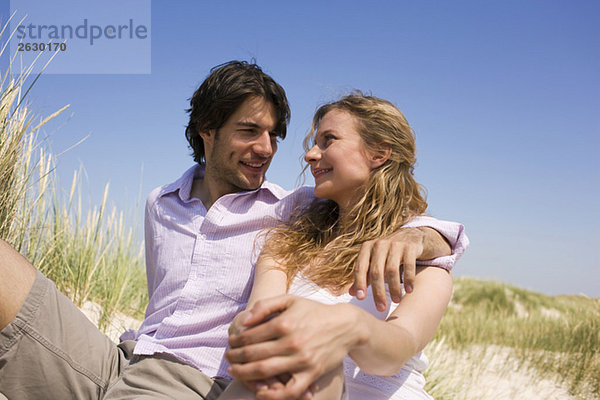 Deutschland  Ostsee  Junges Paar in Dünen sitzend  Portrait