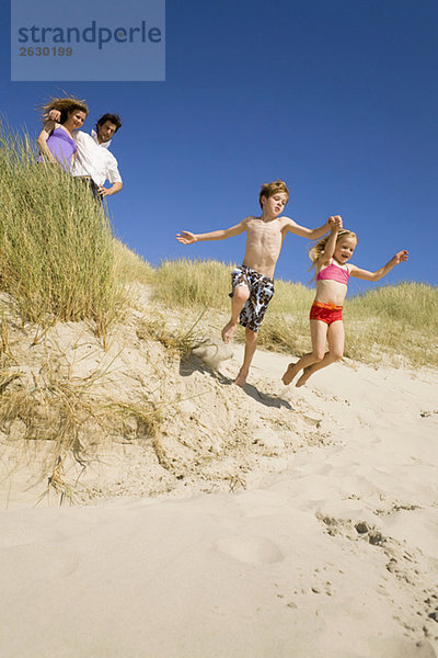 Deutschland  Ostsee  Familie in Sanddünen  Kinder springen über Sanddünen