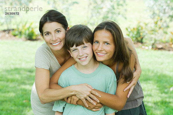 Mutter mit Sohn und jugendlicher Tochter  lächelnd vor der Kamera  Porträt