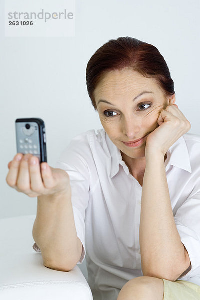 Frau fotografiert sich selbst mit dem Handy