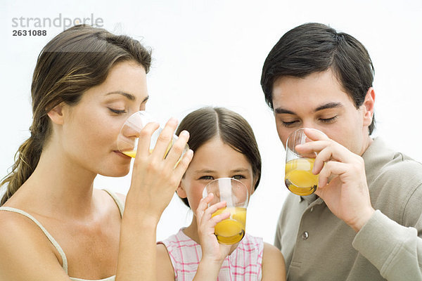 Familie trinkt gemeinsam Orangensaft