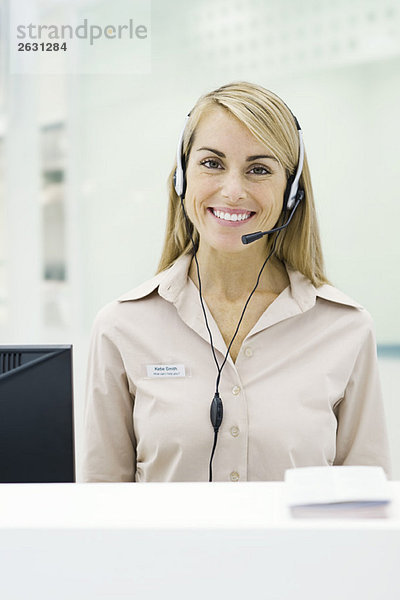 Professionelle Frau mit Headset  lächelnd vor der Kamera