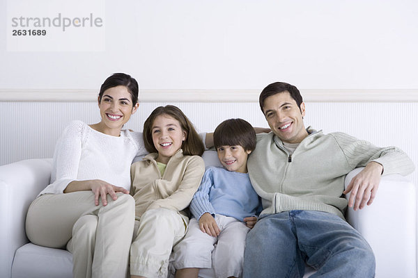 Familie auf dem Sofa sitzend  lächelnd