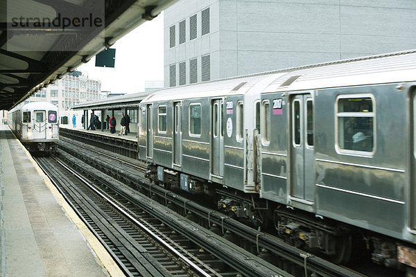 Pendler warten auf die U-Bahn auf dem erhöhten Bahnsteig  IRT Flushing Line of New York City Subway