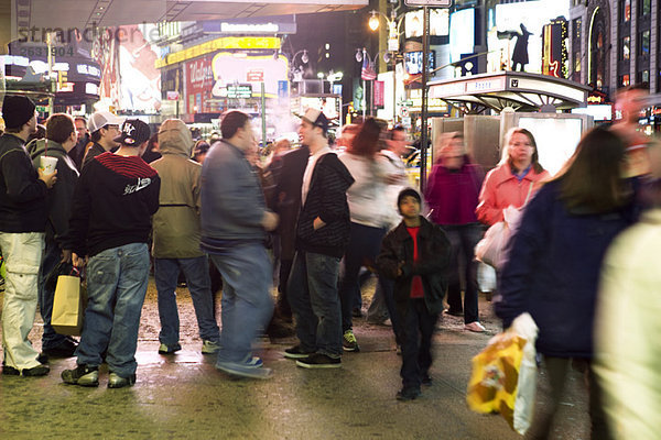 Massenszene auf dem Bürgersteig nahe der Bushaltestelle am Broadway in New York City mit Blick nach Norden am Times Square