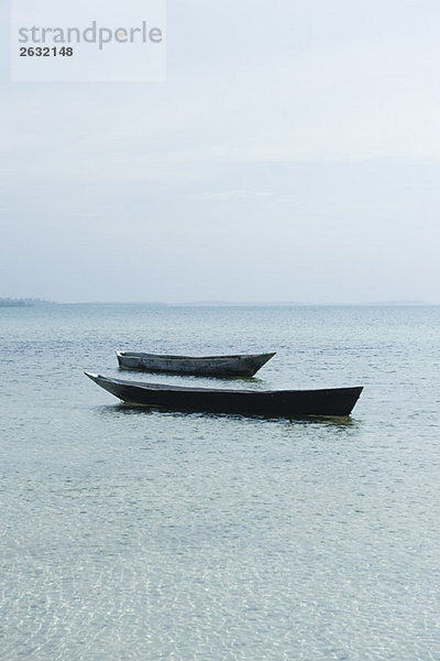 Paar leere Boote nebeneinander schwimmend  Sansibar  Tansania