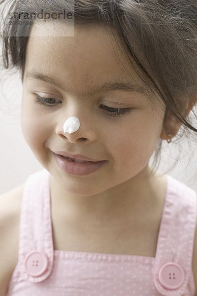 Mädchen mit einem Klecks Creme auf der Nase