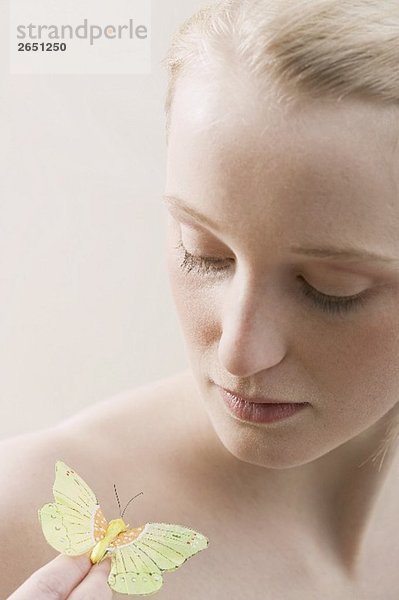 Junge  blonde Frau mit einem künstlichen Schmetterling