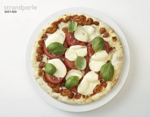 Eine Pizza mit Tomaten  Mozzarella und Basilikum