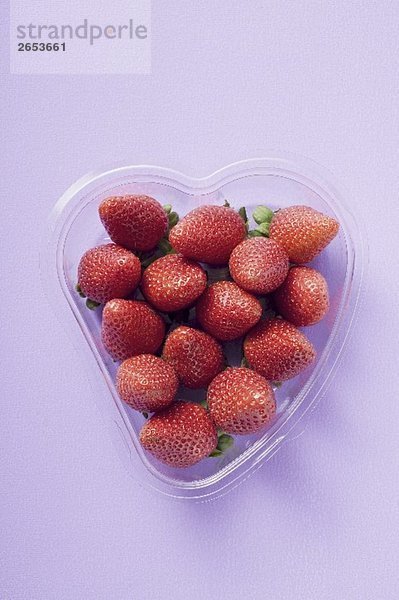 Frische Erdbeeren in herzförmiger Plastikschale