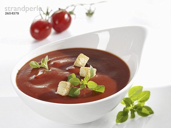 Tomatensauce mit Croutons und Basilikum in weisser Schale