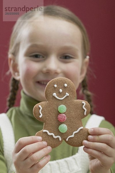 Kleines Mädchen hält weihnachtliche Lebkuchenfigur