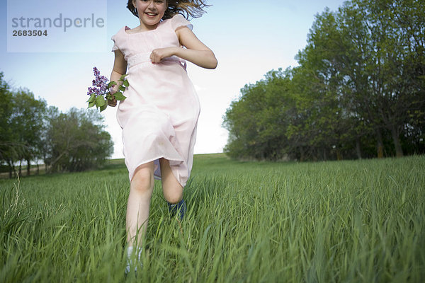 Junges Mädchen durch ein Feld mit Blumen