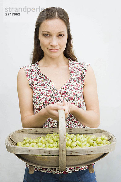 Frau hält Korb mit Beeren